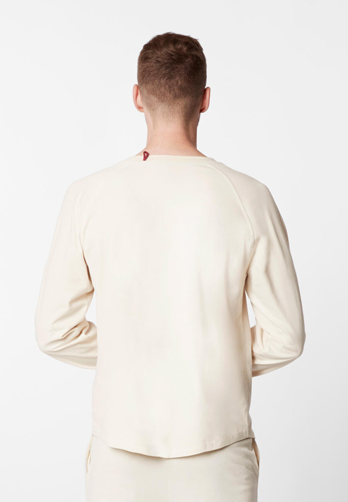 Rückansicht eines Mannes im Pyjama Longsleeve in der Farbe „moon white“.