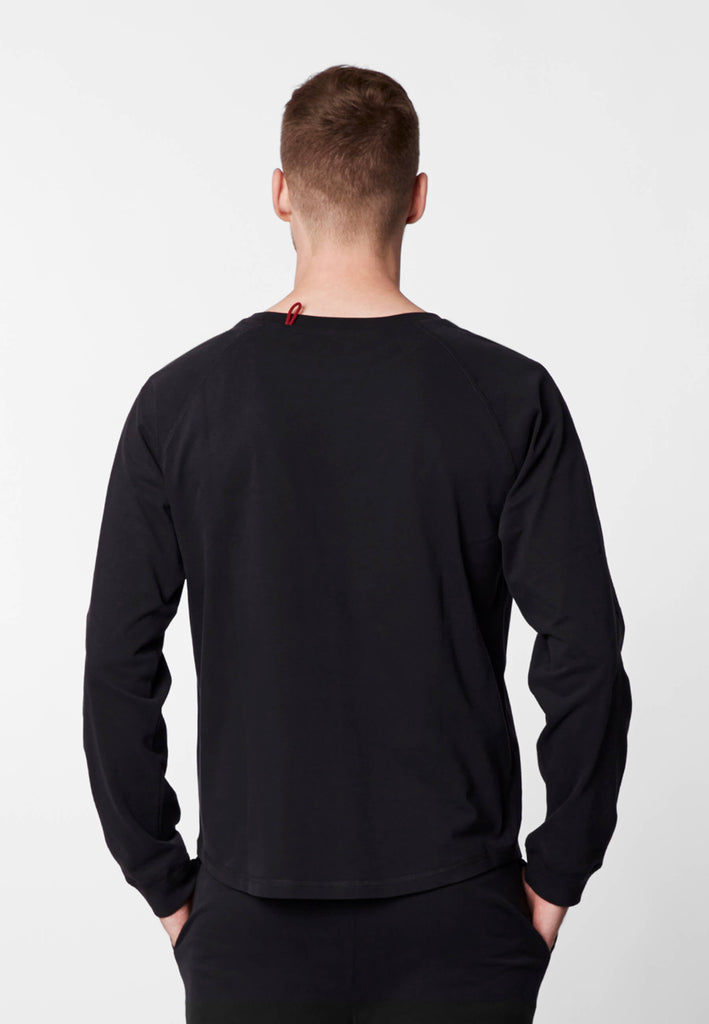 Rückansicht eines Mannes im Pyjama Longsleeve in der Farbe „night black“.