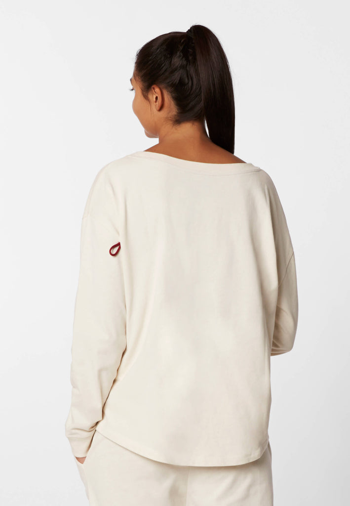 Rückansicht einer Frau im Pyjama Longsleeve in der Farbe „moon white“.