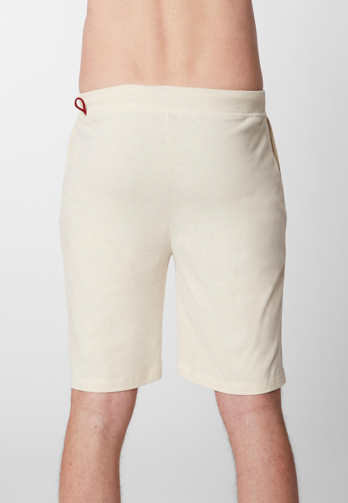 Detail Rückansicht eines Mannes in einer Pyjama Shorts in der Farbe „moon white“.