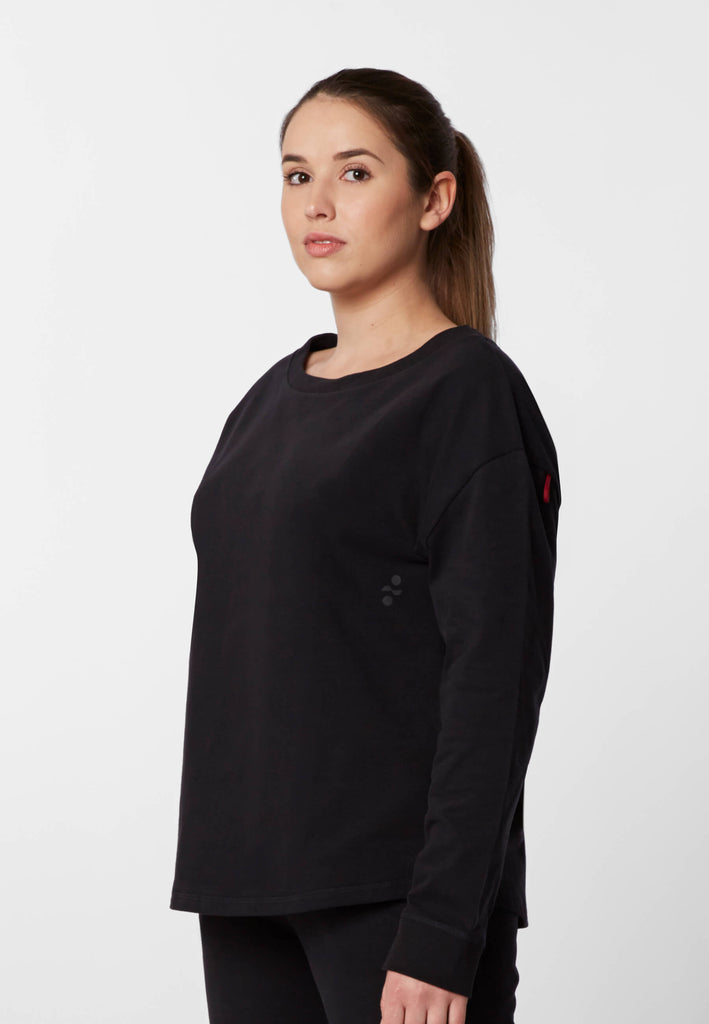 Vorderansicht einer Frau im Pyjama Longsleeve in der Farbe „night black“.