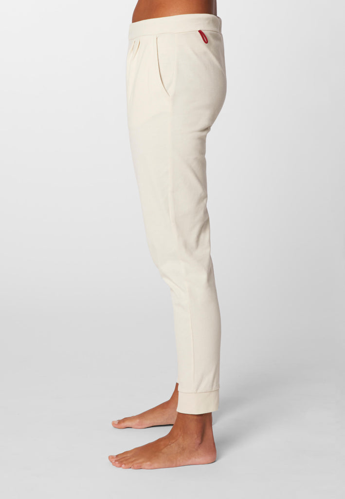 Seitenansicht einer Frau in einer Pyjamahose in der Farbe „moon white“.