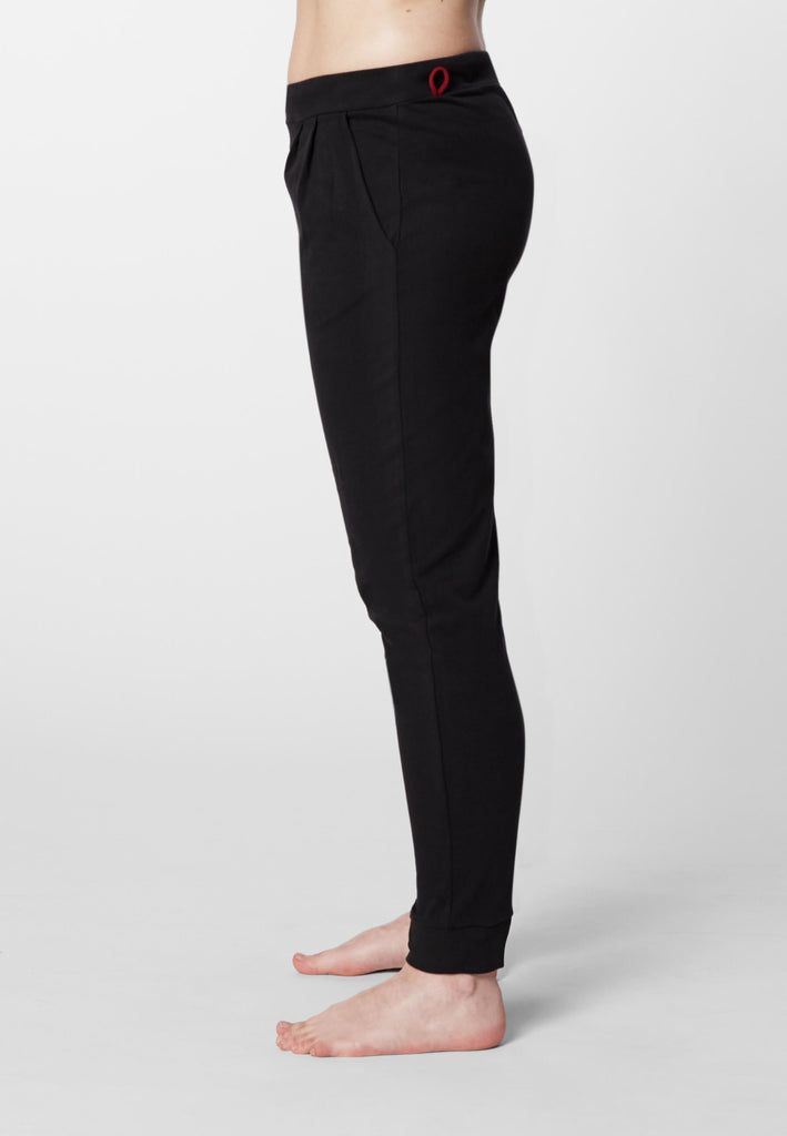 Seitenansicht einer Frau in einer Pyjamahose in der Farbe „night black“.