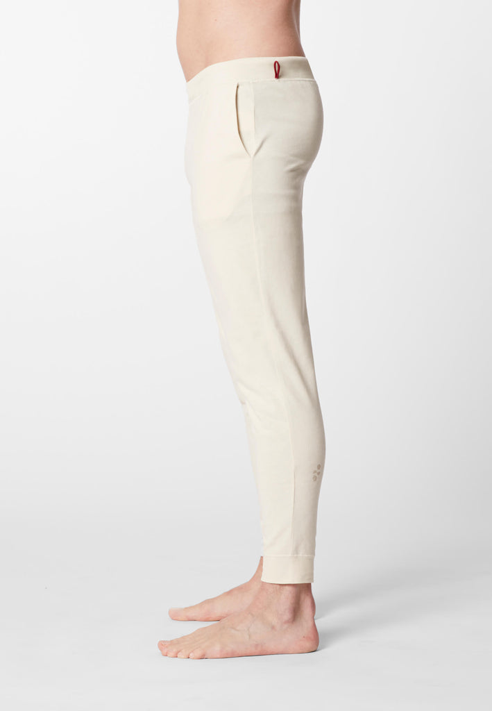 Seitenansicht eines Mannes in einer Pyjamahose in der Farbe „moon white“.