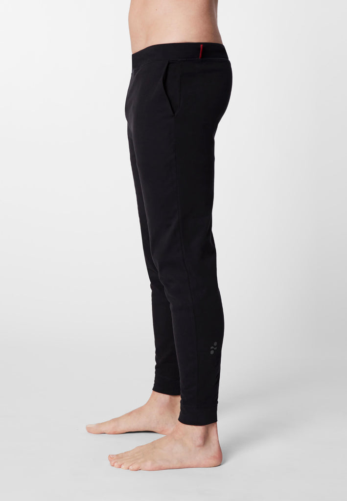 Seitenansicht eines Mannes in einer Pyjamahose in der Farbe „night black“.