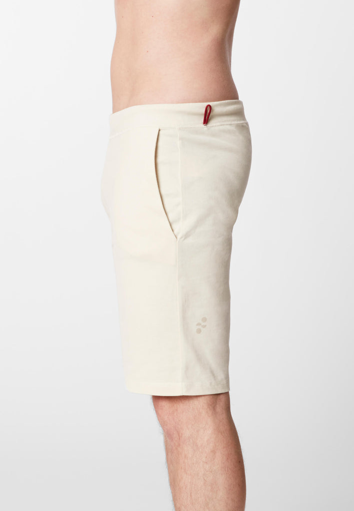 Detail Seitenansicht eines Mannes in einer Pyjama Shorts in der Farbe „moon white“.