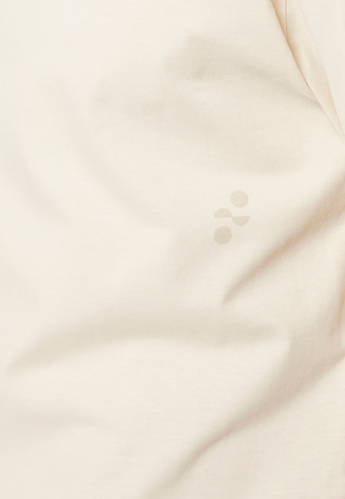 Detailbild vom Logo-Print im Ton-in-Ton Kontrast auf dem Baumwollstoff in der Farbe „moon white“.