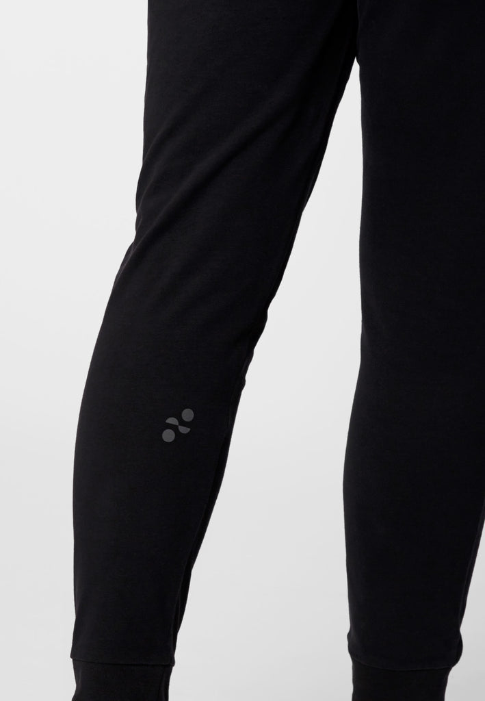 Detailbild vom Logo-Print am Wadenbein im Ton-in-Ton Kontrast auf dem Baumwollstoff in der Farbe „night black“.