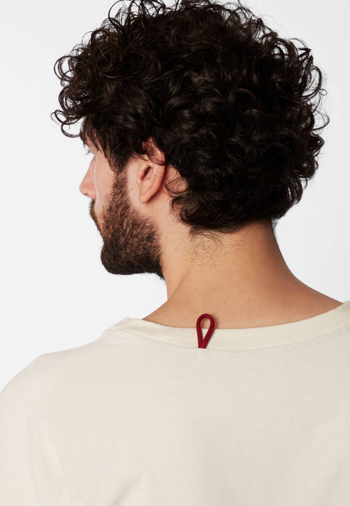 Detailbild einer roten Schlaufe am Nachthemd in der Farbe „moon white“ an der Nackennaht.