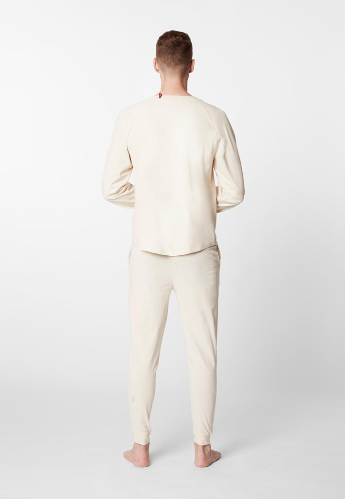 Ganzkörper Rückansicht eines Mannes im Pyjama Longsleeve und Pyjamahose in der Farbe „moon white“.