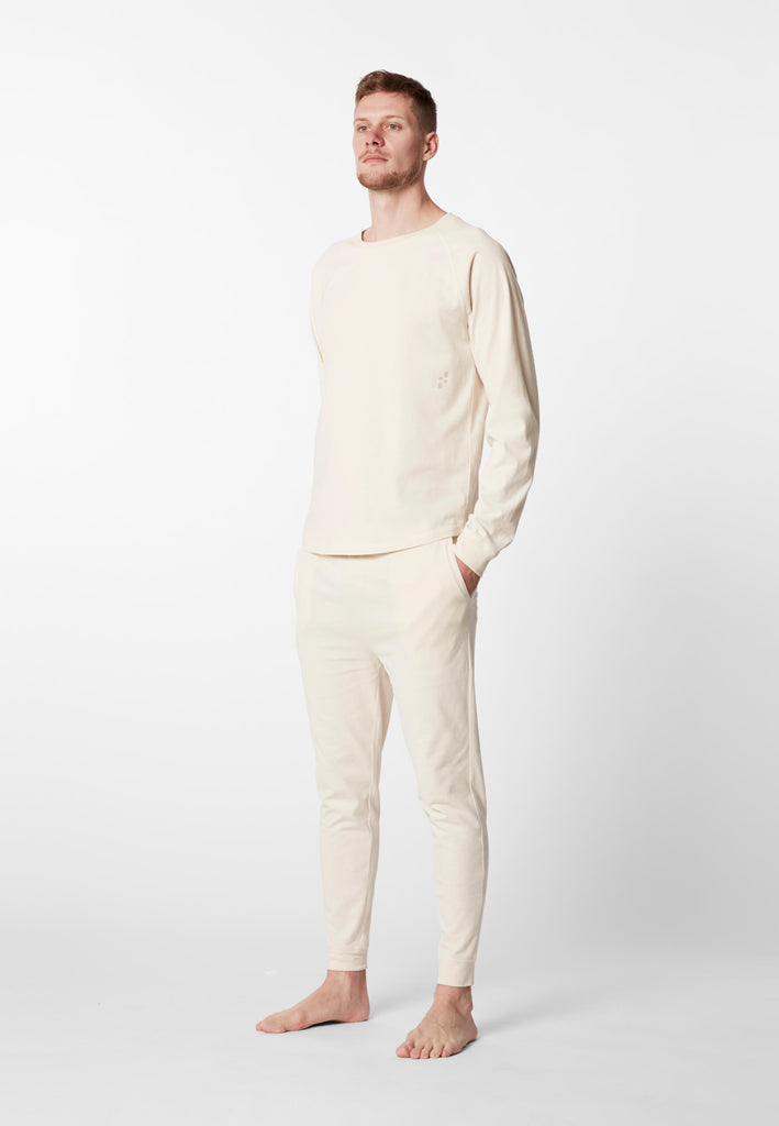 Ganzkörper Vorderansicht eines Mannes in einer Pyjamahose und eines Pyjama Longsleeves in der Farbe „moon white“.